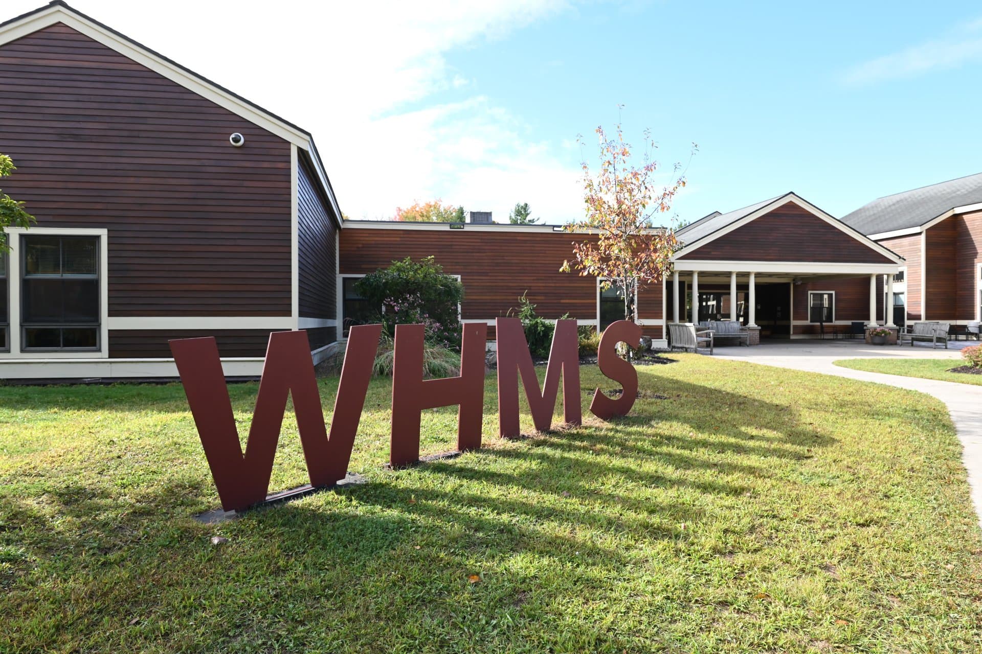 The Woodland Hill Montessori School campus in North Greenbush, with the red WHMS letters on the lawn